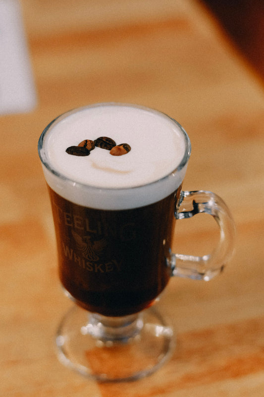 Irish Coffee met warme koffie, whiskey en een dikke laag slagroom in een glas met steel