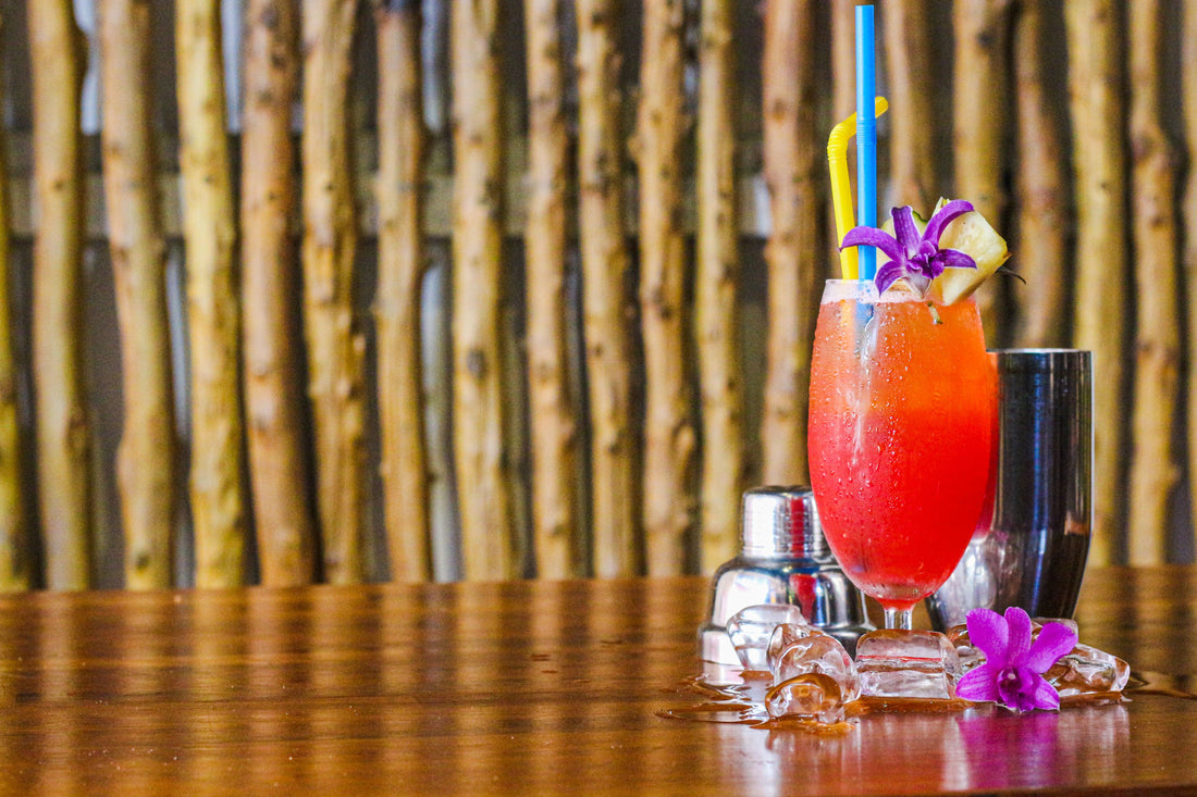 Tropische Mai Tai cocktail met orchidee als garnering in een glas met crushed ice op een houten tafel
