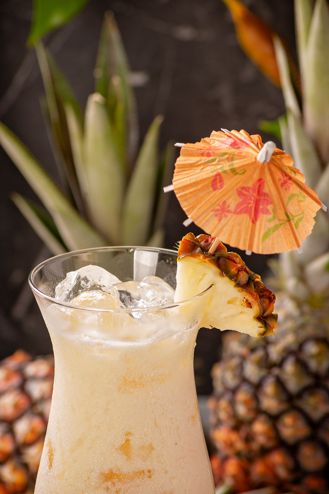 Romige Piña Colada cocktail met vers ananasschijfje en cocktailparaplu in een hoog glas