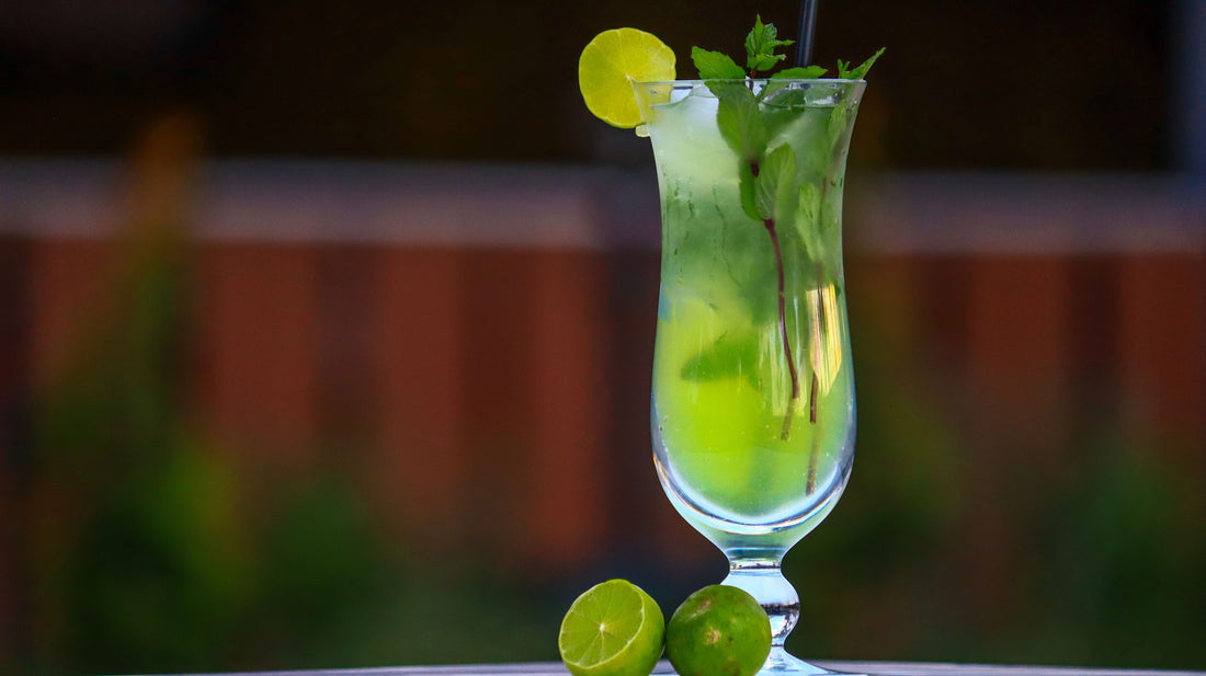 Mojito met verse munt, limoenschijfjes en ijs in een hoog glas