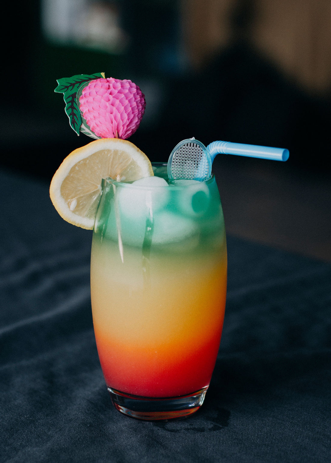Fruitige Sex on the Beach cocktail in een longdrinkglas met ijs, gegarneerd met sinaasappel en een cocktailkers