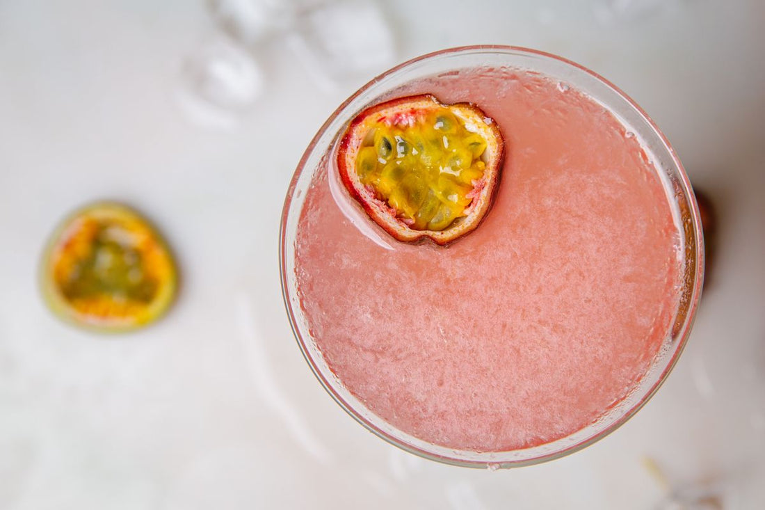 Pornstar Martini in gekoeld coupeglas met halve passievrucht en een glaasje prosecco ernaast