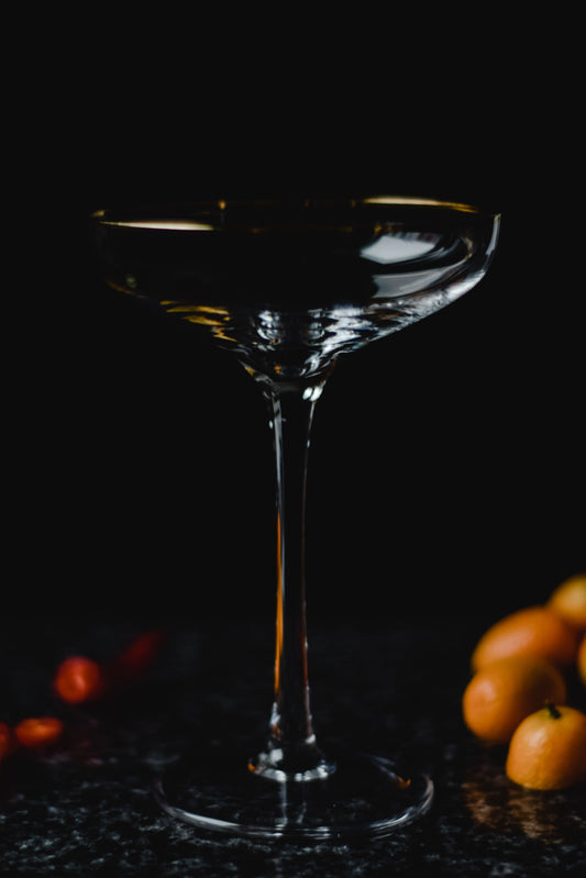 Sidecar cocktail in een gekoeld coupeglas met een sinaasappelschil, geserveerd tegen een donkere achtergrond