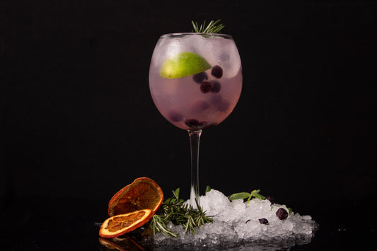 Bramble cocktail met gin en bramenlikeur, geserveerd op crushed ice in een tumbler glas met bosvruchten